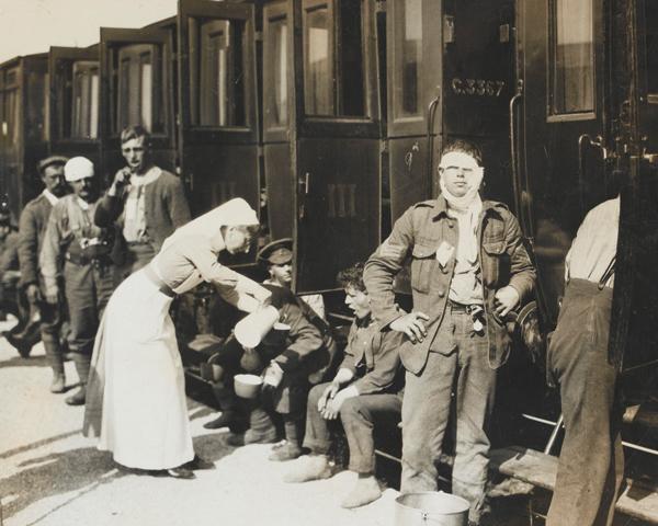 A nurse serves tea to wounded and gassed soldiers, 1915