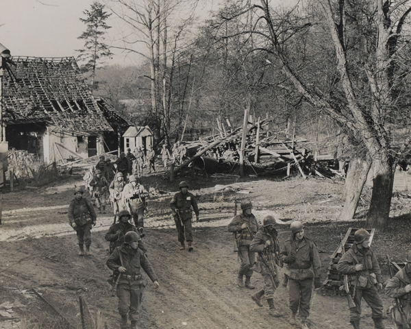 Soldiers of the US 7th Army move through a shell-torn village, 1944