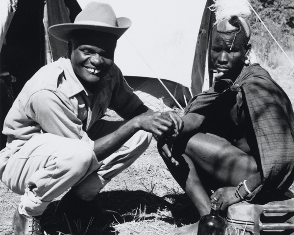 A medical orderly of the 4th King's African Rifles attends to a Kenyan villager, 1955