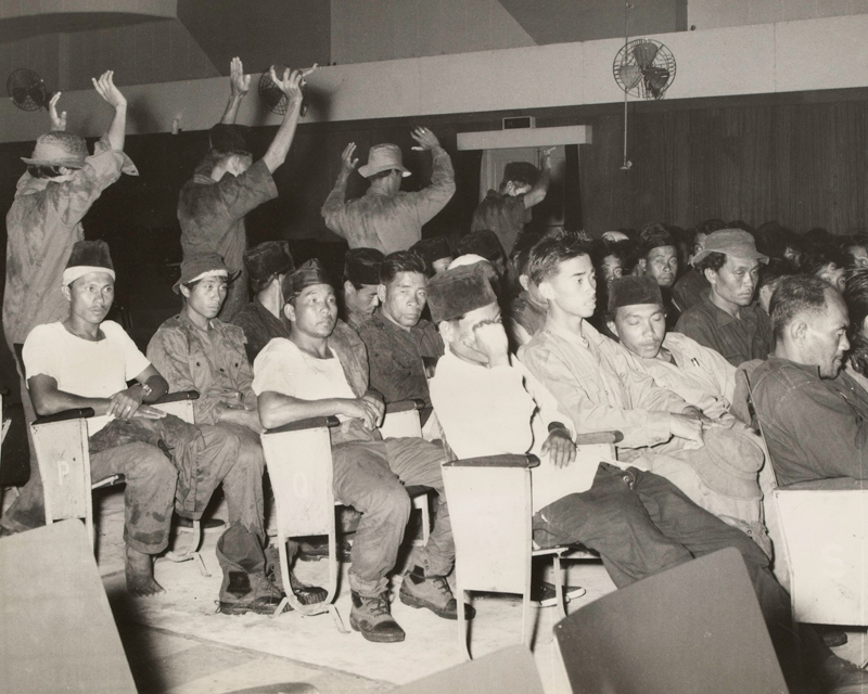 Rebel prisoners under Gurkha guard in a Brunei cinema, December 1962