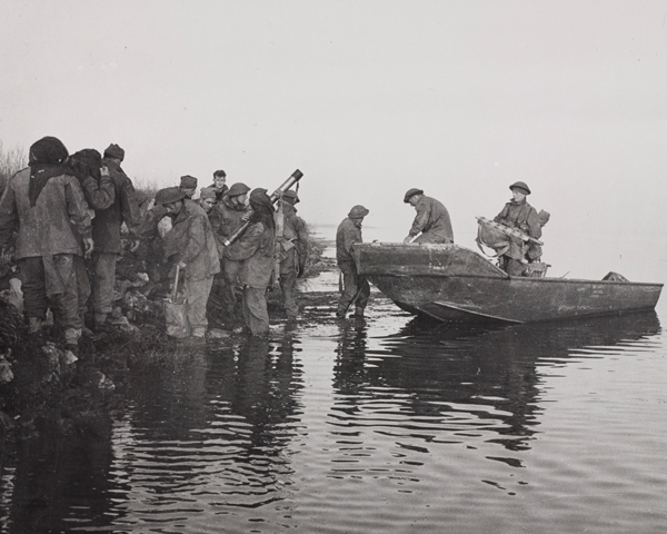 Men of 40 Royal Marine Commando unload a boat at Lake Comacchio, Italy, where they captured crossings vital to the main infantry advance, 11 April 1945