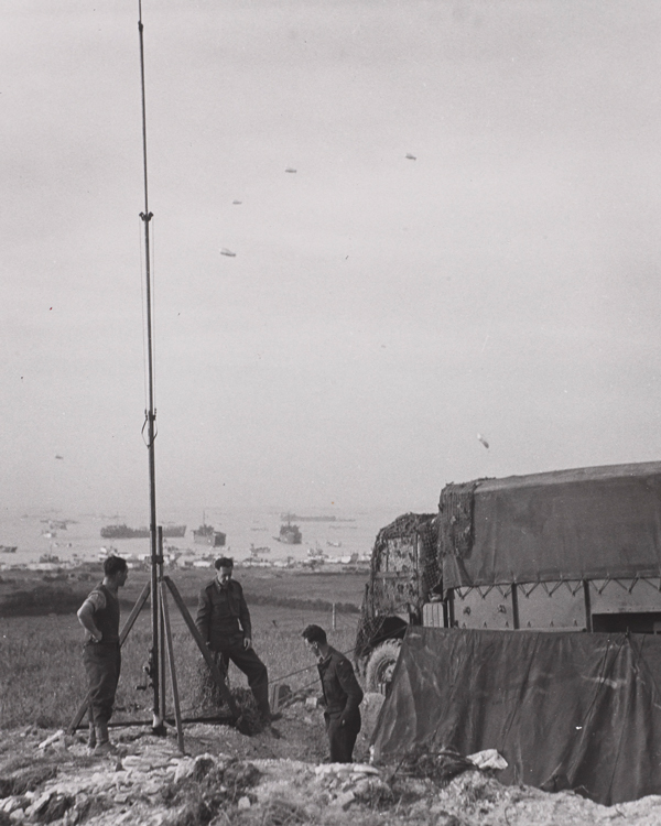 A signals unit erecting a radio mast on one of the Normandy beaches, June 1944 