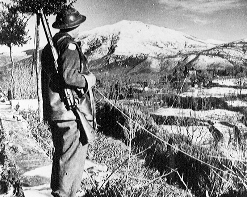 Driver CA Langford, Royal Army Service Corps, looks over the snow covered peaks of the American Fifth Army's front in Italy, 1944