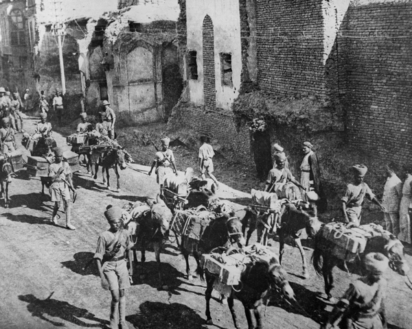 Indian soldiers march through Baghdad with donkeys loaded with supplies and ammunition, 1917 