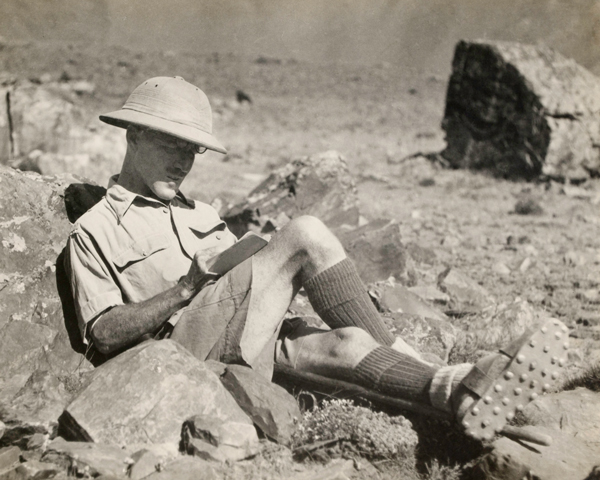 Colonel Guy Hamilton Russell filling in his game book while on a hunting expedition, 1930