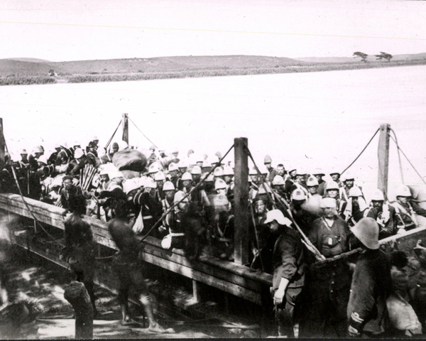 A company of the 99th Regiment crossing into Zululand by barge, 1879