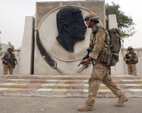 A soldier of 3 Para passes a monument to Saddam, Basra, April 2003