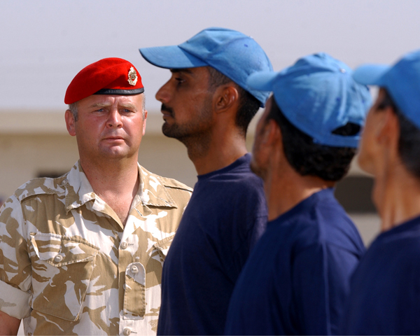 A Royal Military Policeman instructs Iraqi police recruits, 2003