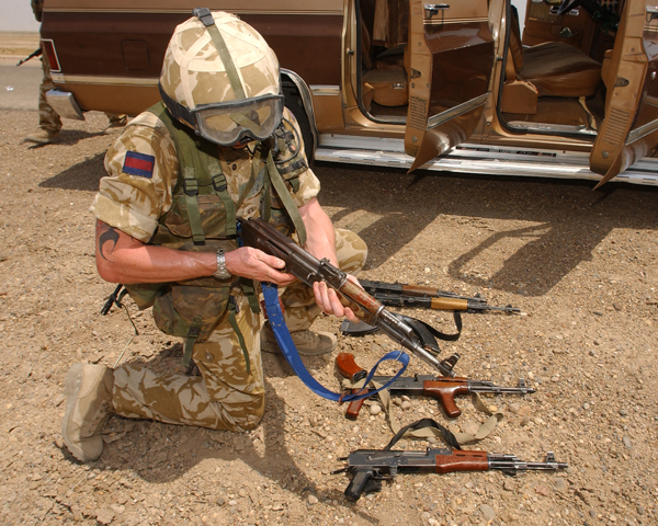 Checking arms discovered during a vehicle search, Iraq, 2003