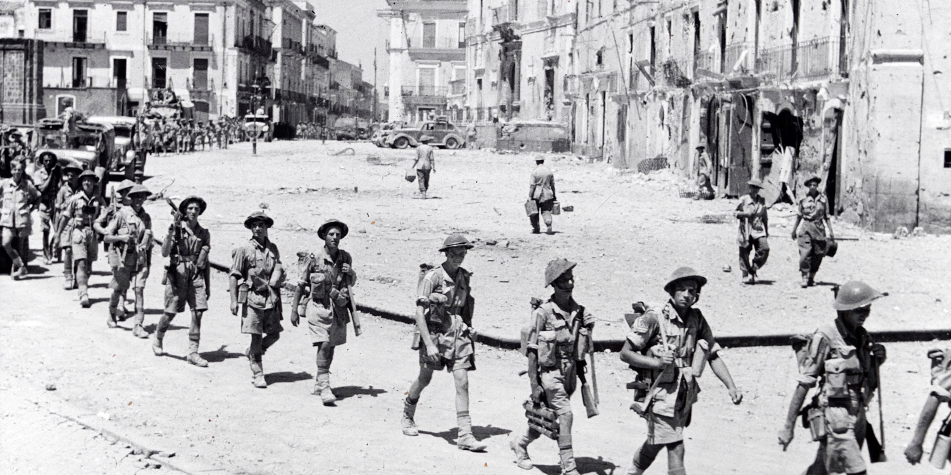 Men from the 5th Battalion, The Northamptonshire Regiment, entering the town of Adrano, Sicily, August 1943