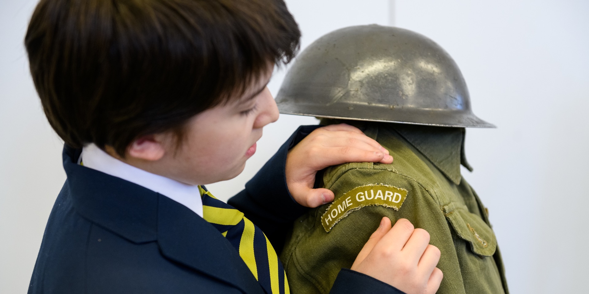 School boy examining a Home Guard uniform