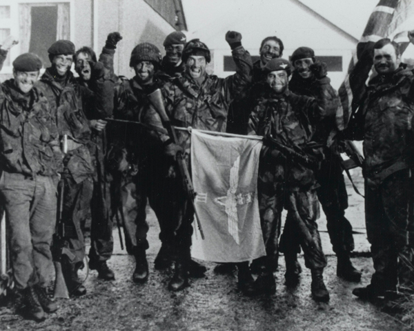 Men of the 3rd Parachute Regiment with their regimental ensign after the liberation of Port Stanley, June 1982