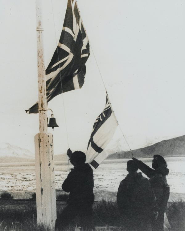 Royal Marines hoisting the Union Jack and White Ensign over Grytviken, capital of South Georgia, April 1982