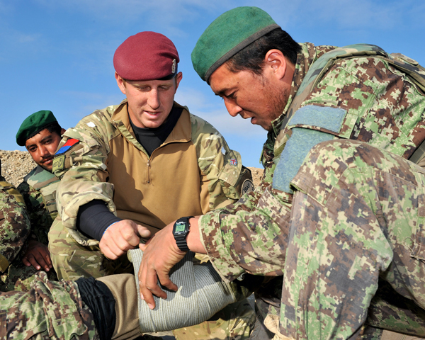 Corporal Harvey Davies, Royal Army Medical Corps, training an Afghan soldier to apply a field dressing, 2011