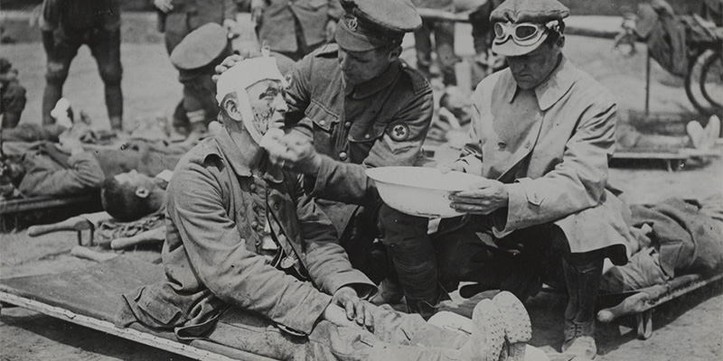 A British medical orderly treats a wounded German soldier, c1916