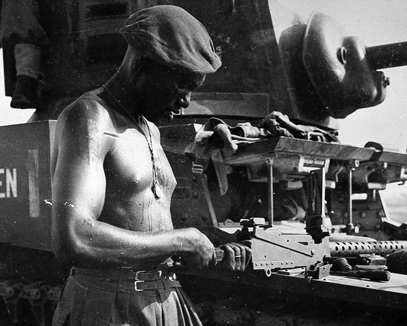 A soldier from the East African Reconnaissance Regiment, checking a machine gun, Burma, 1945