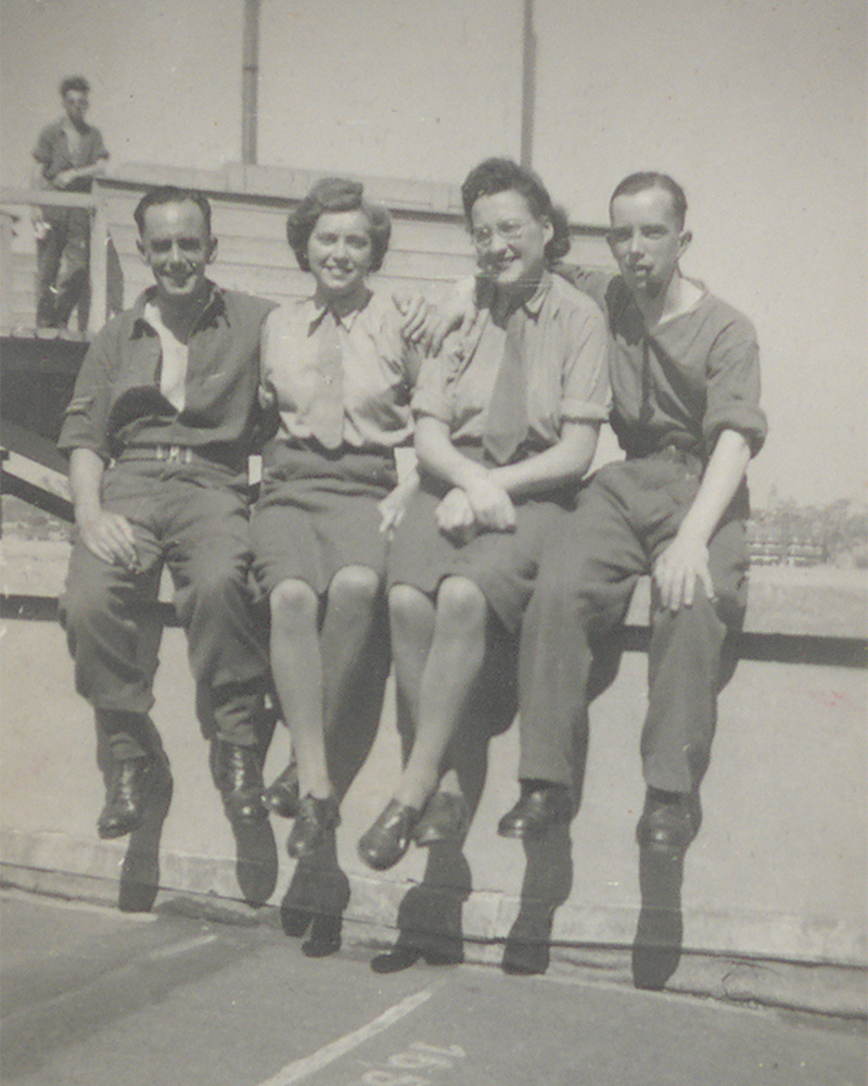Members of the Auxiliary Territorial Service posing for a photograph with two men on the roof of the Résidence Palace, Brussels, Belgium, August 1945