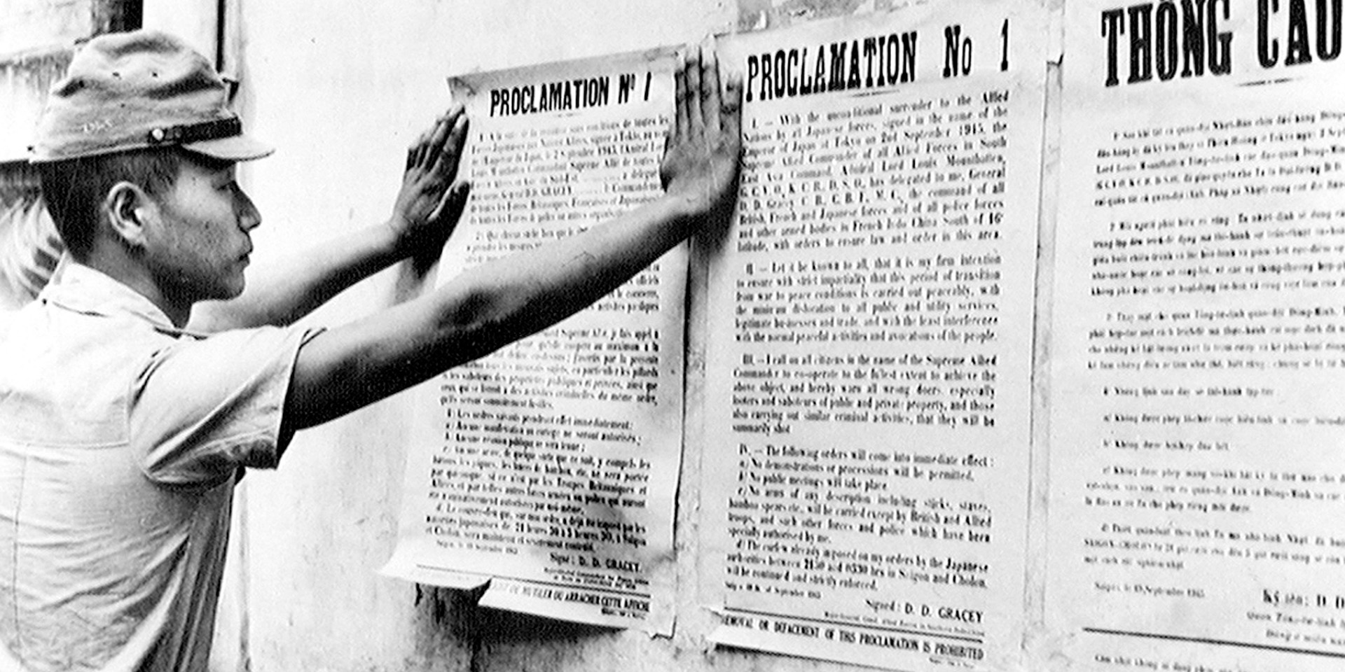 A Japanese soldier reads a poster describing arrangements for the Allied military occupation of Japan, 1945