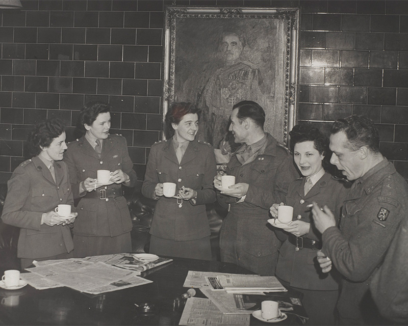 Male and female officers mingle during a break in their training course, October 1945