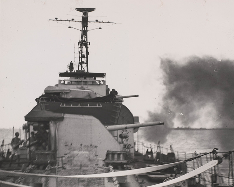A Royal Navy destroyer bombarding the coast in support of the Army operations in the city of Surabaya, East Java, 1945