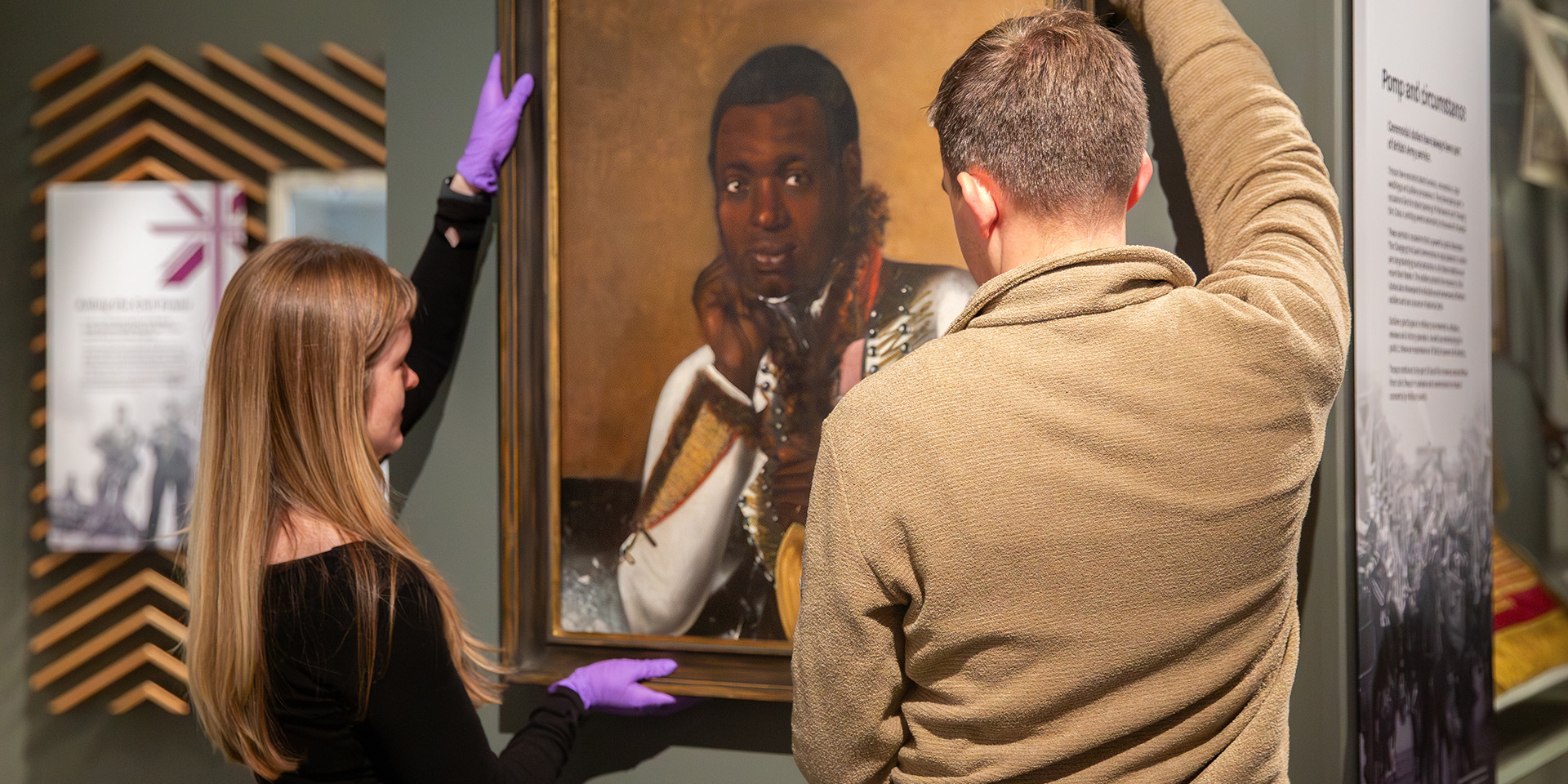 Installing the portrait of the bandsman in the Army at Home gallery