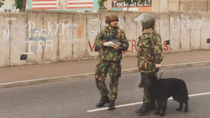 A bomb disposal officer and infantry officer patrol West Belfast, 1992