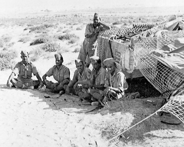 Indian troops shelter in the shade of their vehicle, 1942