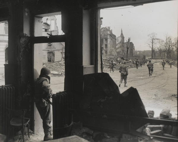 An American patrol advances towards the centre of a war-torn German town, 1945