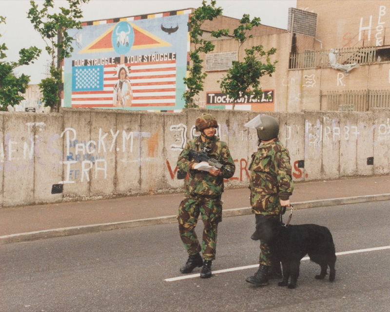 Soldiers of 2nd Battalion, The Royal Anglian Regiment on patrol with a dog in Belfast, c1980