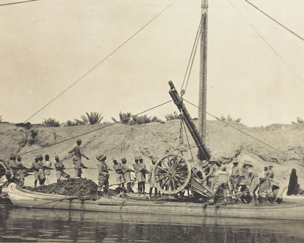 Guns from 1/5th Hampshire Howitzer Battery being loaded onto a raft at Basra, 1915