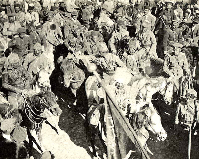 Assyrian troops led by Agha Petros (saluting) with a captured Turkish banner in the foreground, 1918