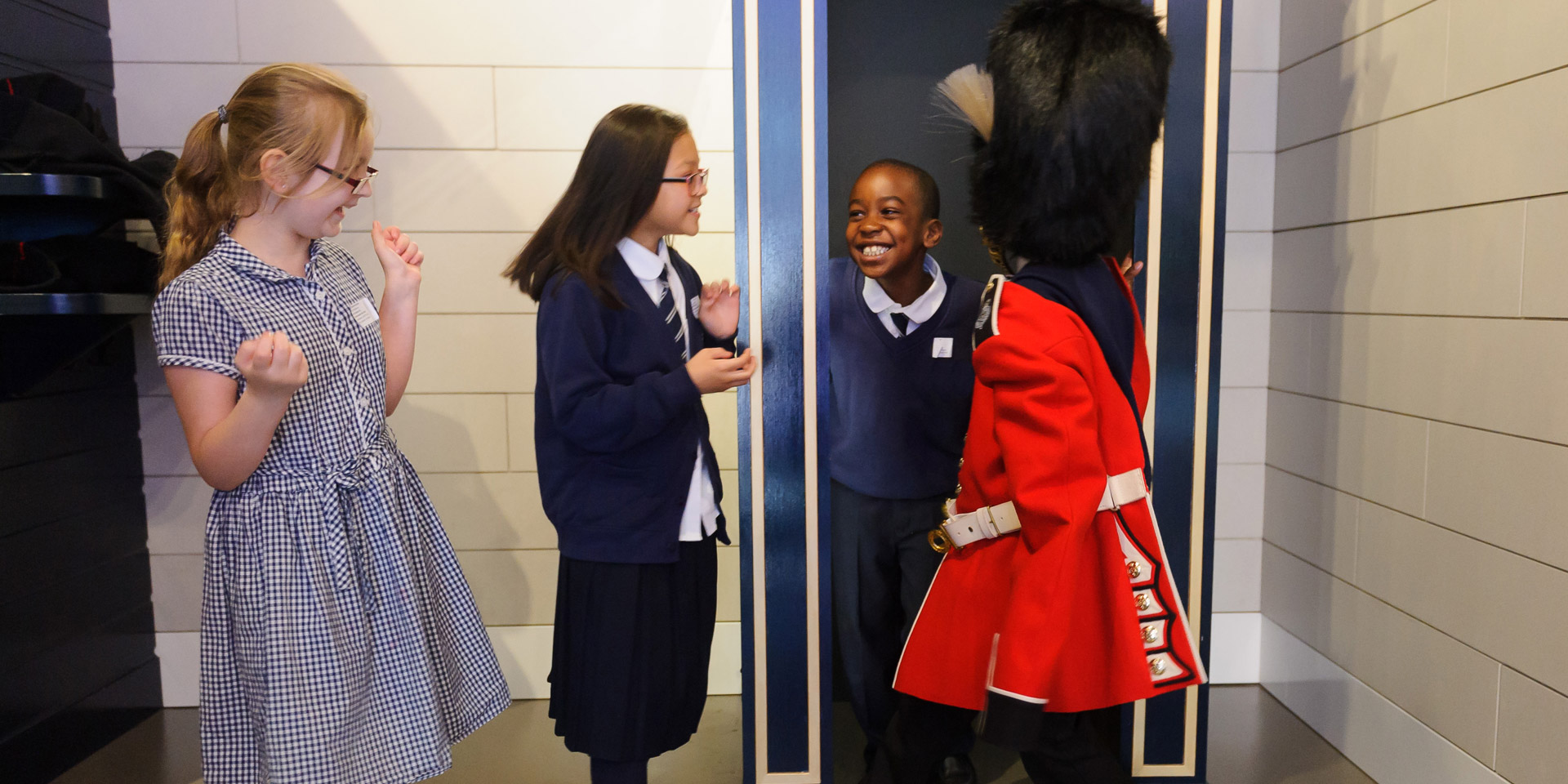 Kids trying on uniforms in Society gallery