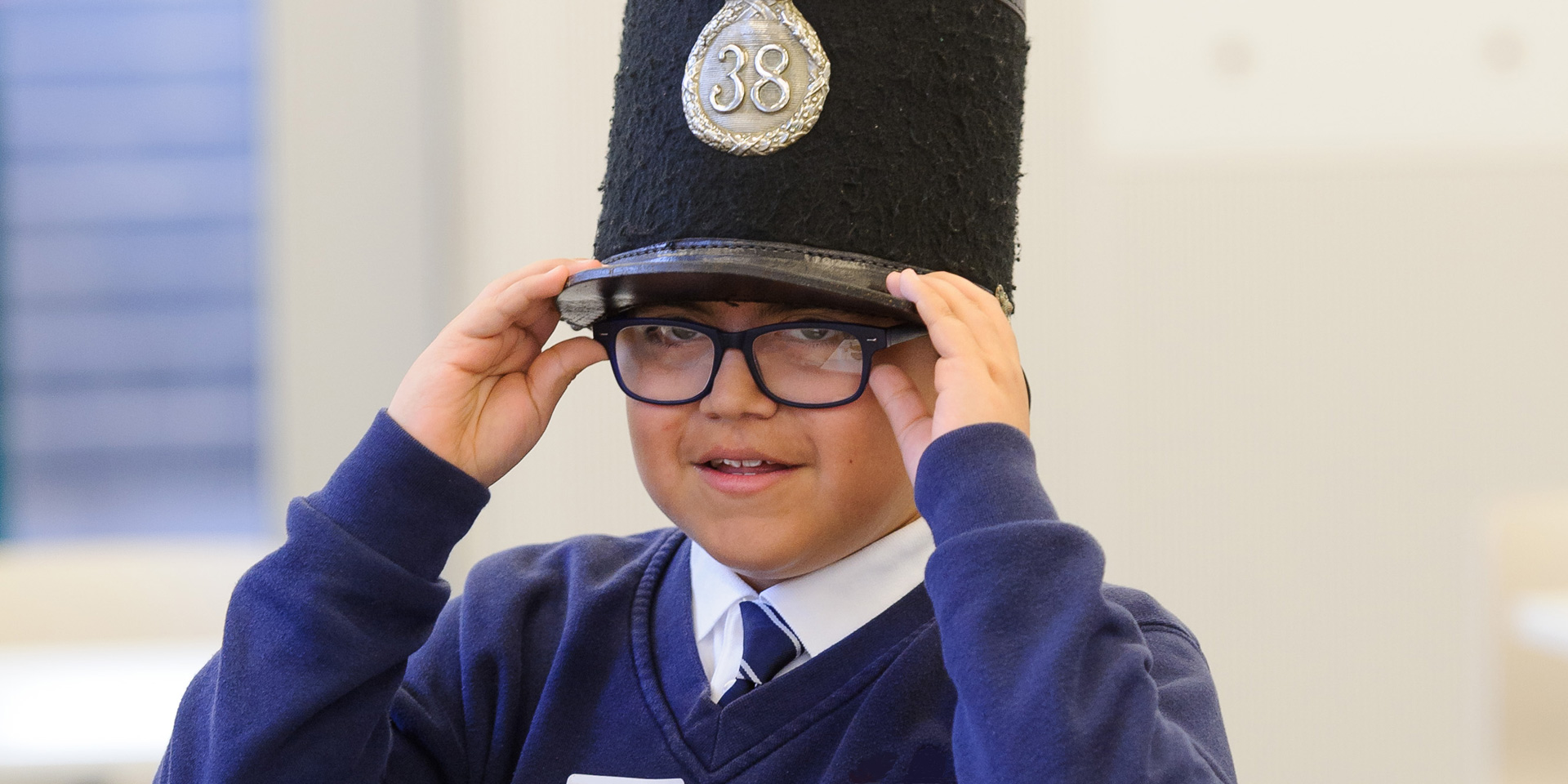 School boy trying on a Crimean-era military cap