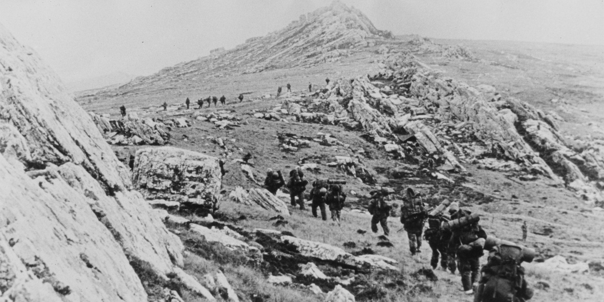 British troops march across the rocky Falklands terrain, 1982