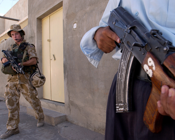 A private of the Cheshire Regiment with an Iraqi policeman, Basra, June 2004