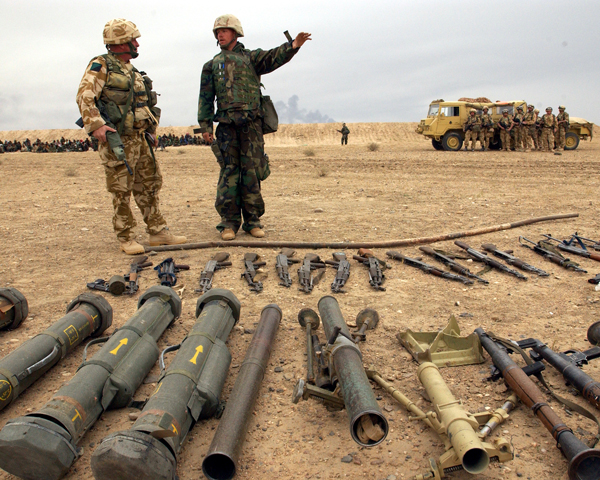 A US Marine officer and British officer with captured weapons and prisoners, March 2003