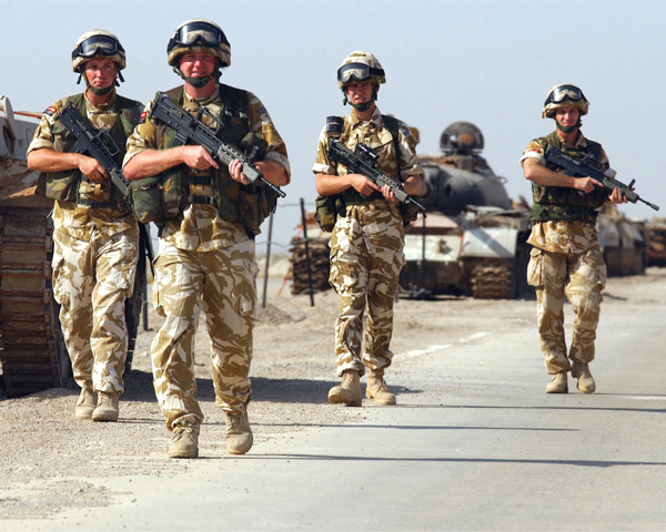 British troops advance past knocked-out Iraqi tanks, 2003