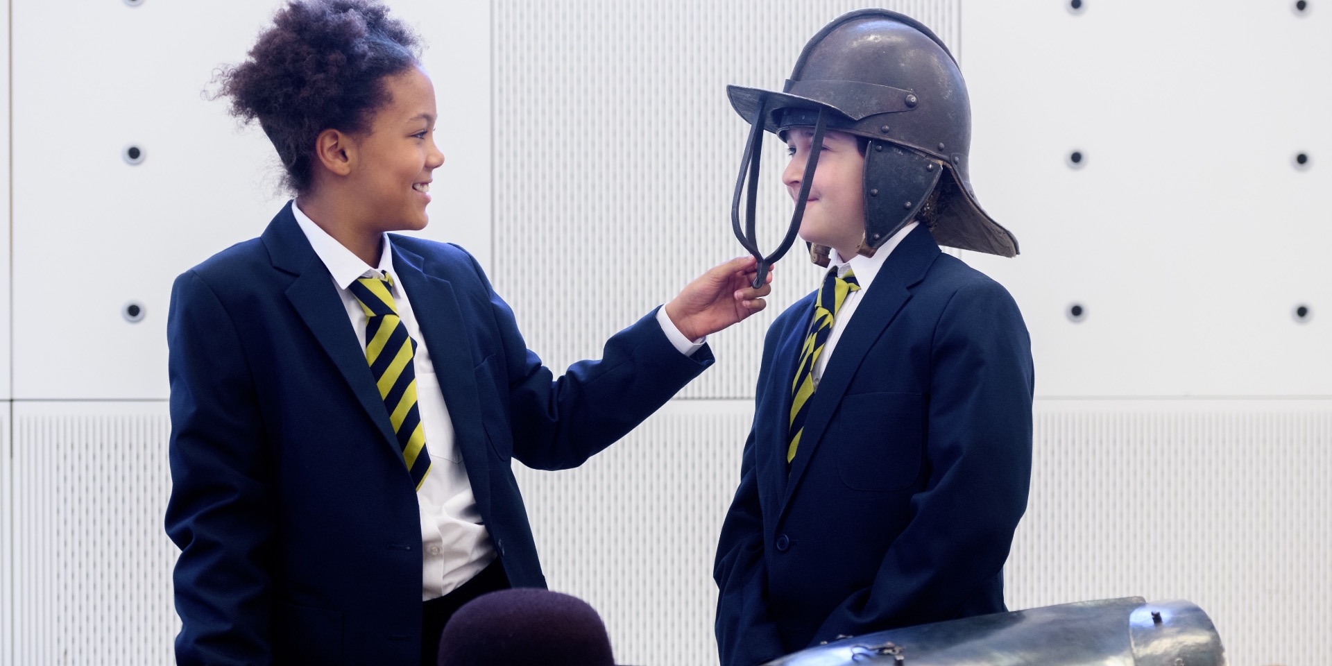 School children examining 17th-century military uniform