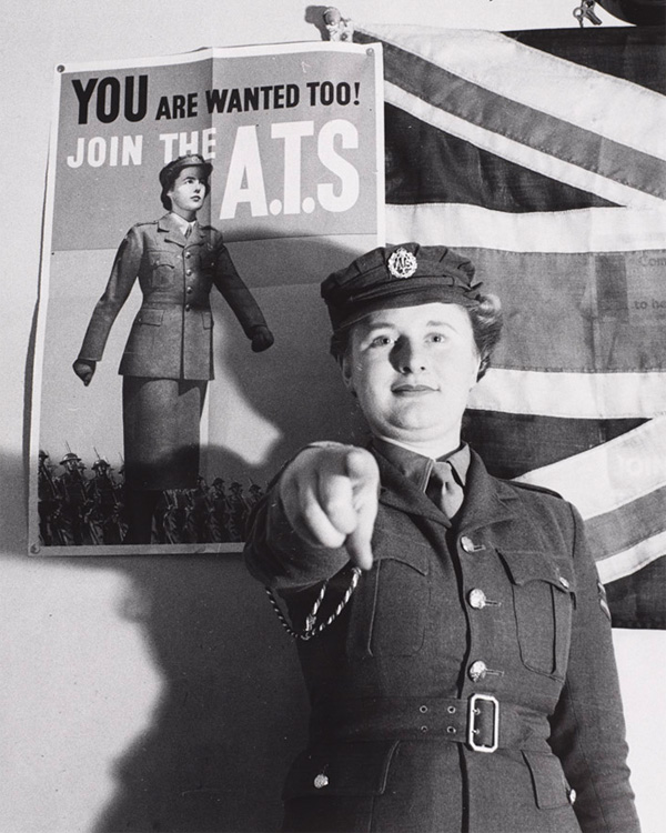 Private Mary Catherine Roberts posing alongside her recruiting poster, c1941