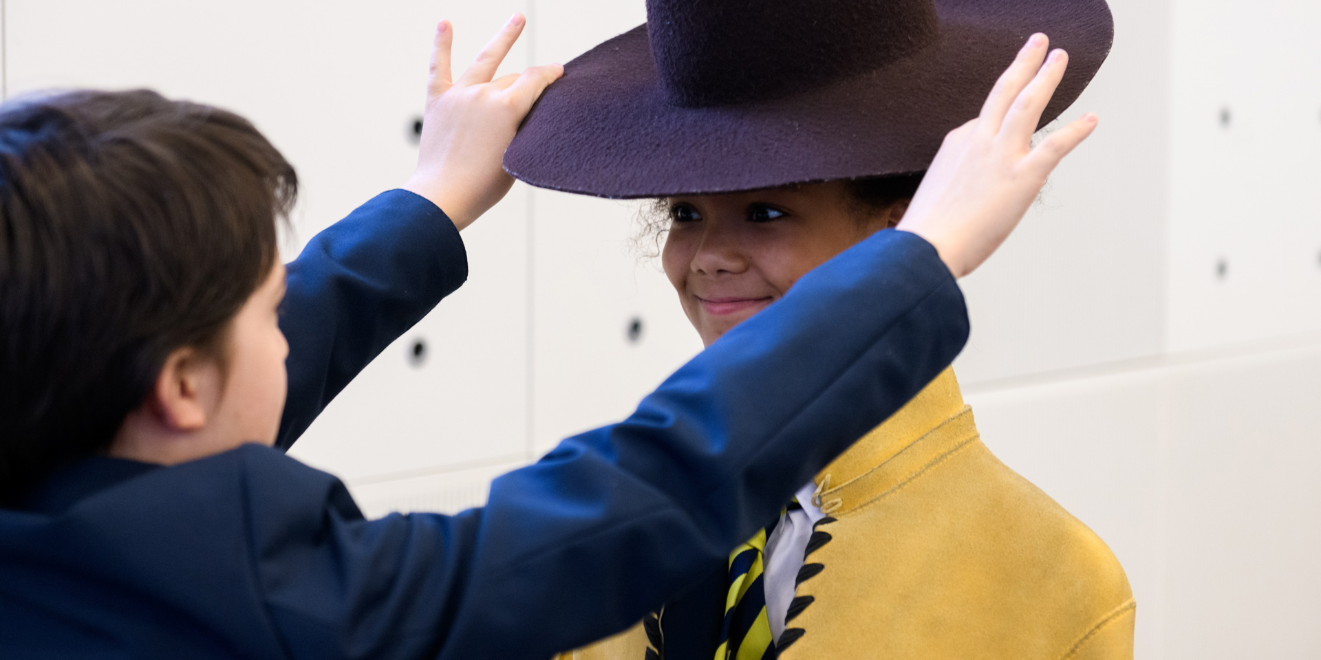 Children dressing up in a jacket and hat