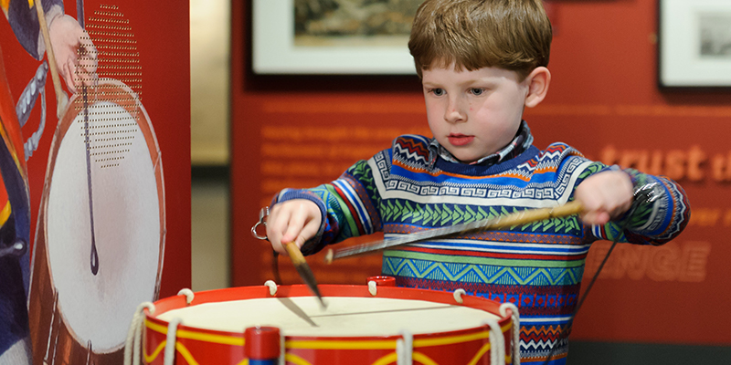 Child playing on a drum