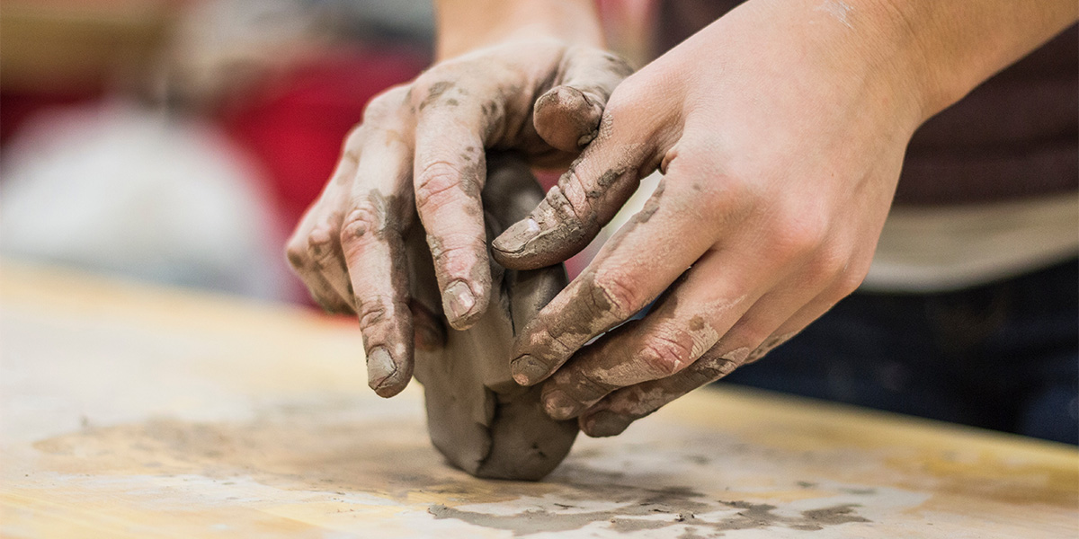 Hands sculpting with clay