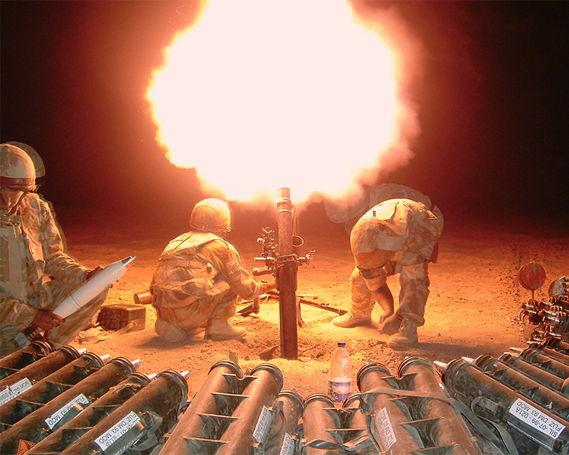 Soldiers of the Royal Irish Regiment fire mortar rounds during a contact at night in Musa Qala, 2006