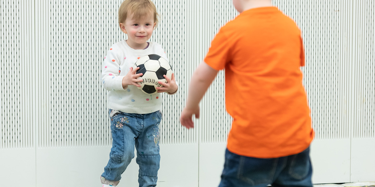 Toddlers playing with a football