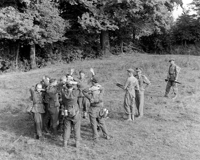 Major Toby Waite, the commander of 'A' Company, King’s Royal Rifle Corps, oversees the surrender of German soldiers, 1944