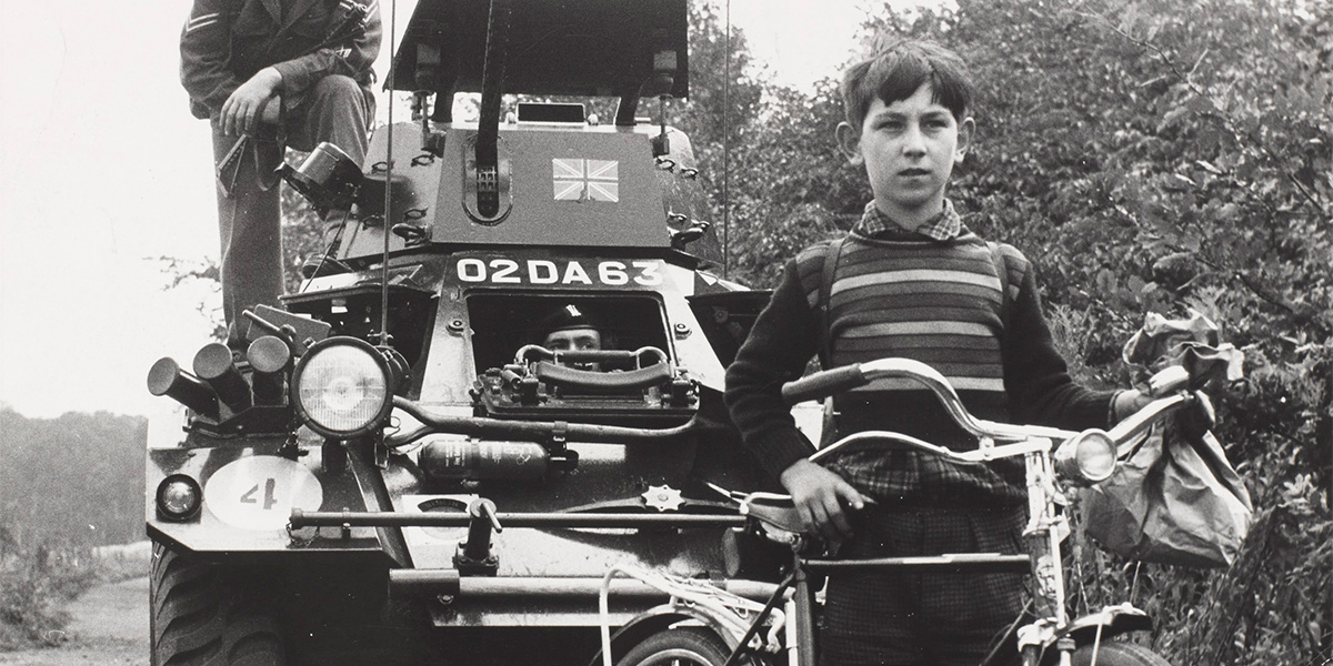 Schoolboy in front of a British Army scout car West Germany, 1961