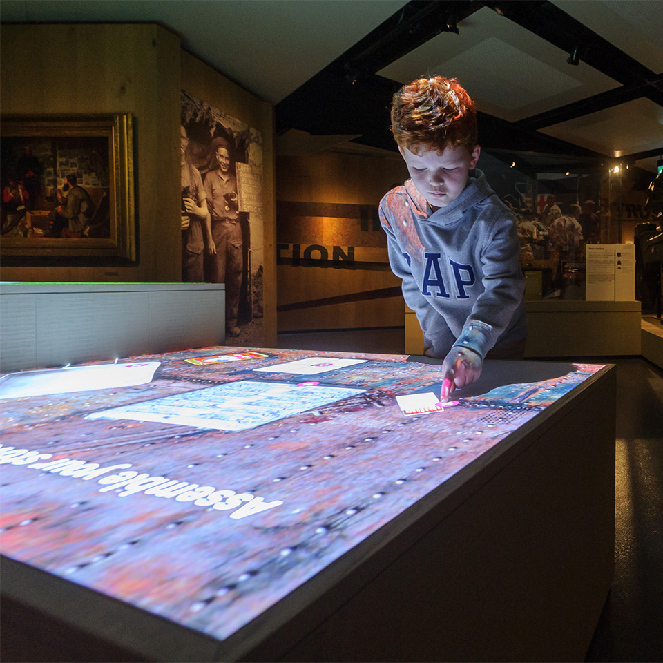 Child interacting with the army rations table in the Soldier gallery