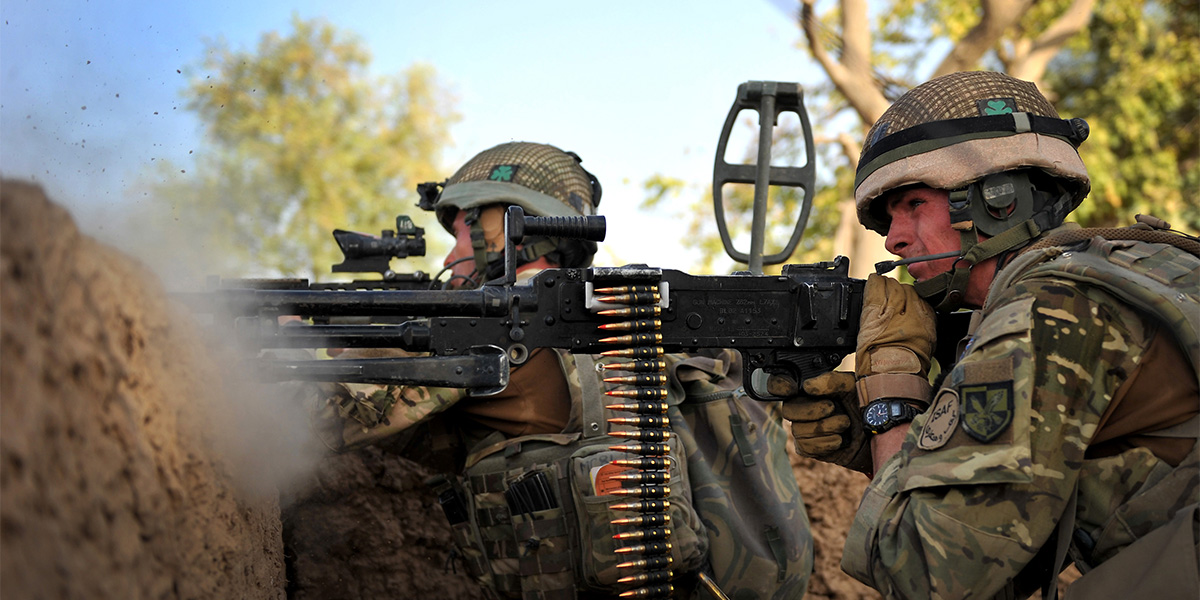 A British soldier of the Royal Irish Regiment returns fire when his patrol is ambushed, Helmand, 2010