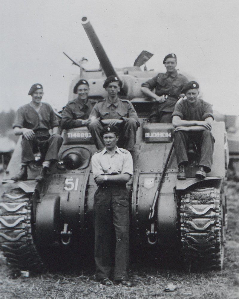 Members of No 3 Squadron, 2nd Armoured Battalion, Grenadier Guards, with a Sherman tank, Rottenburg airfield, Germany, 9 June 1945