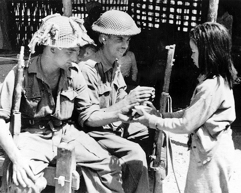Soldiers of 2nd Battalion, The Royal Berkshire Regiment, with a local girl in Burma, 1945